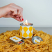 Candle being lit with a match on a bed of pasta, with a hand holding the match.