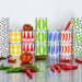 Colorful stacked cans on a reflective surface with tomatoes and peppers.