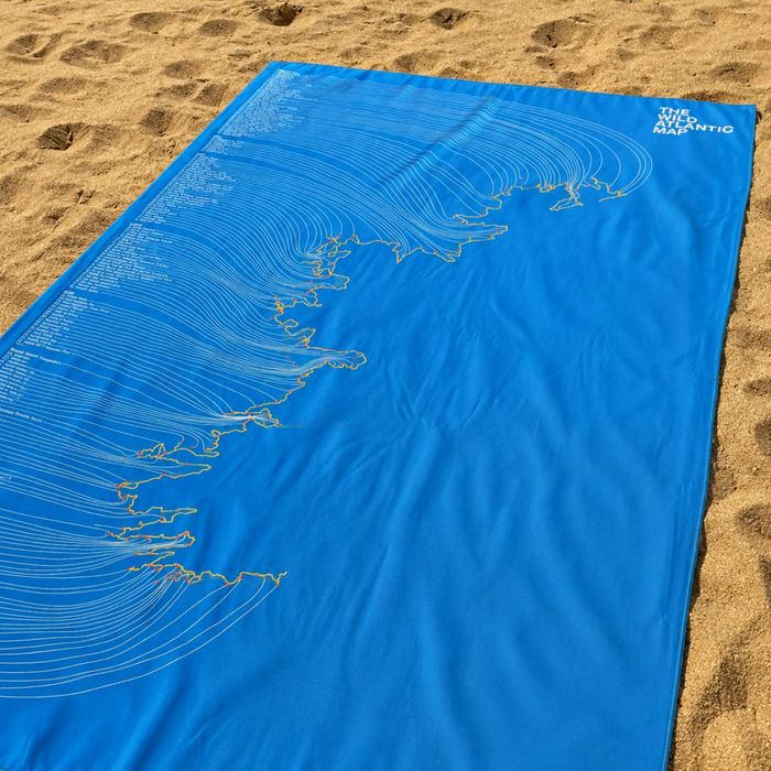 Blue towel with white graphics on a sandy background