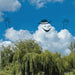 Smiling cloud with arms and a hat peeking out from behind trees against a blue sky.