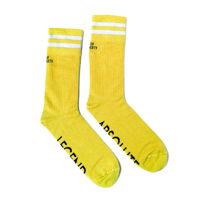 Two yellow socks with white stripe across the ankle of them. Have a very long ankle to about mid shin length and irishscksociety written on the ankle in small black letter. Absolute legend is written across sole in capital black letters. The socks are laid down on the surface flat and the ankle curves to the right
