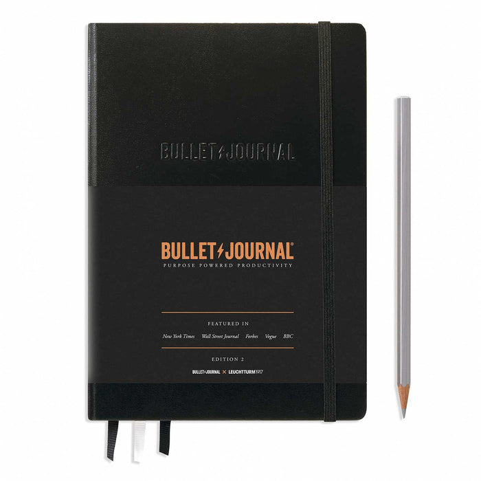 Bullet Journal Edition 2 black notebook with black and copper paper wraparound and silver pencil to right