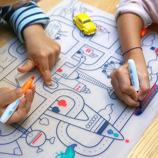 two children's hands holding markers over a place mat with a city and road scene printed in blue