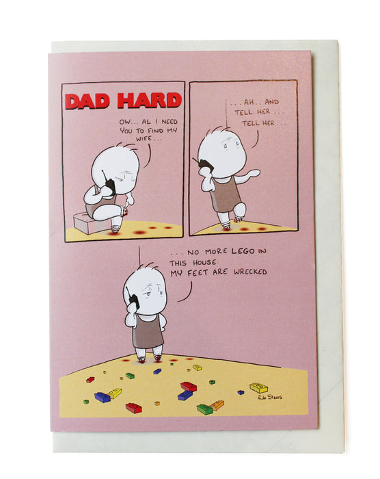 fathers day card with white envelope on white background. pink card with comic style boxes and image of cartoon dad standing on multicolor lego. 