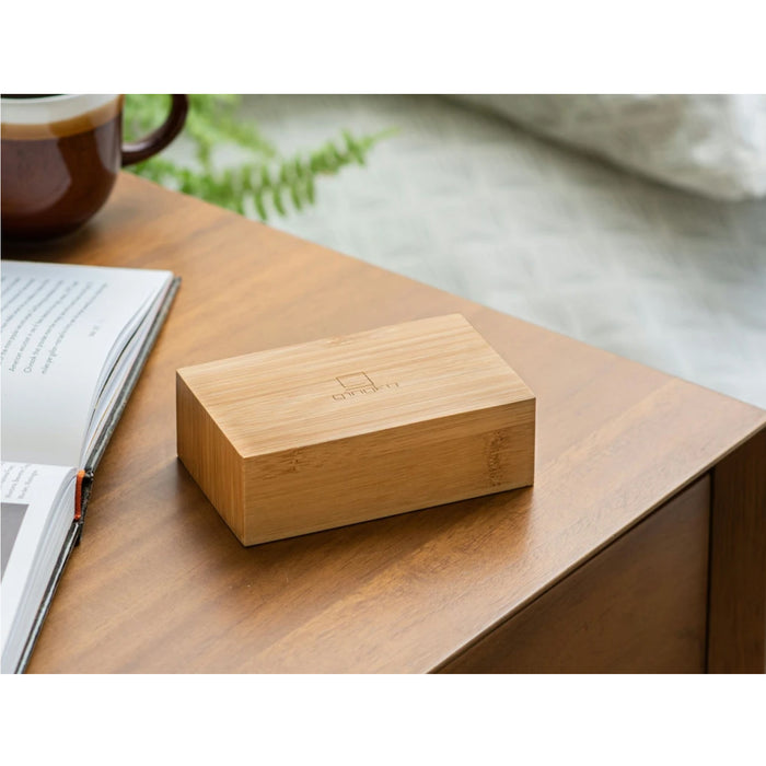 wooden flip clock on a wooden table with a mug, book and pen in the background