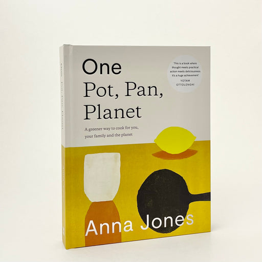 the book is standing upright on a white background. the bottom half of the book has a mustard colour and abstract lemon, pan and glass on it