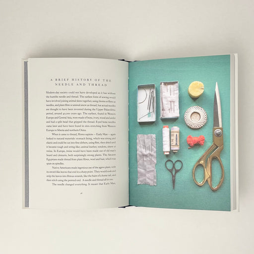 the inside of the book, a picture of the contents of a sewing box laid out on a turquoise background.