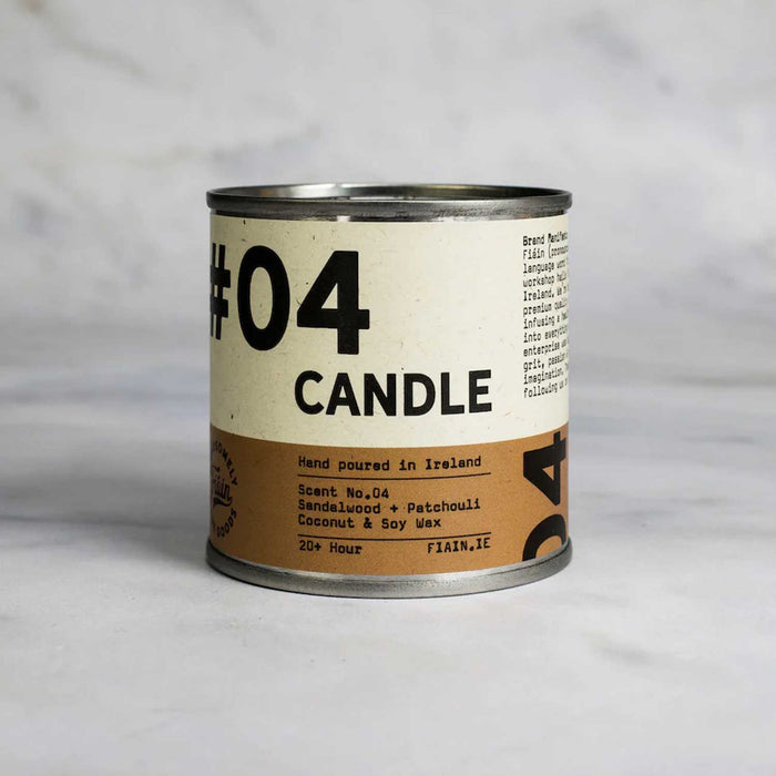 round metal tin with white and tan label with 04 candle in black text, against a grey backdrop