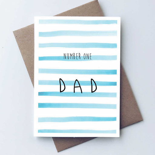 Greeting card in front of brown envelope blue and white stirpes with number one dad in black skinny text on front