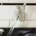 White rabbit toothbrush holder stuck to a tiled wall holding a toothbrush