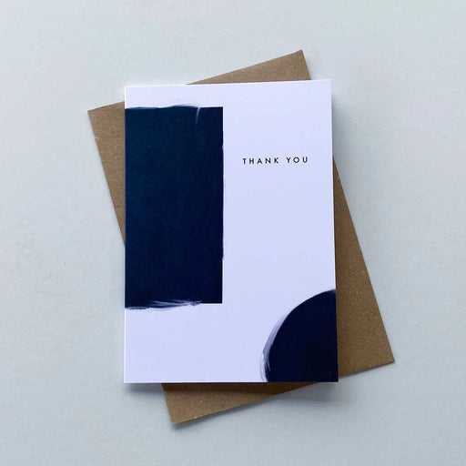 white greeting card with navy brushed rectangle to left and qaurter circel in bottom right corner