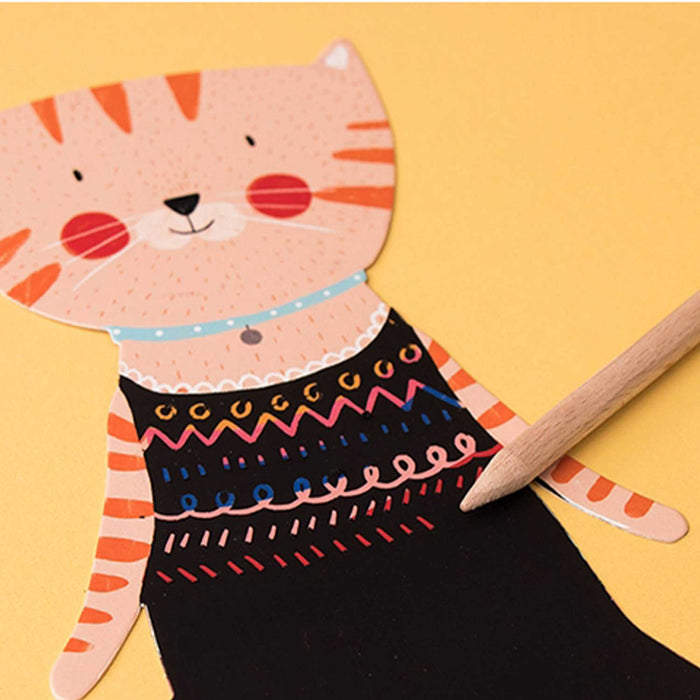 paper cat in a black dress with coloured patterns on dress and wooden dowel 