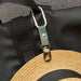 metal clip attached to wicker hat and balck bag