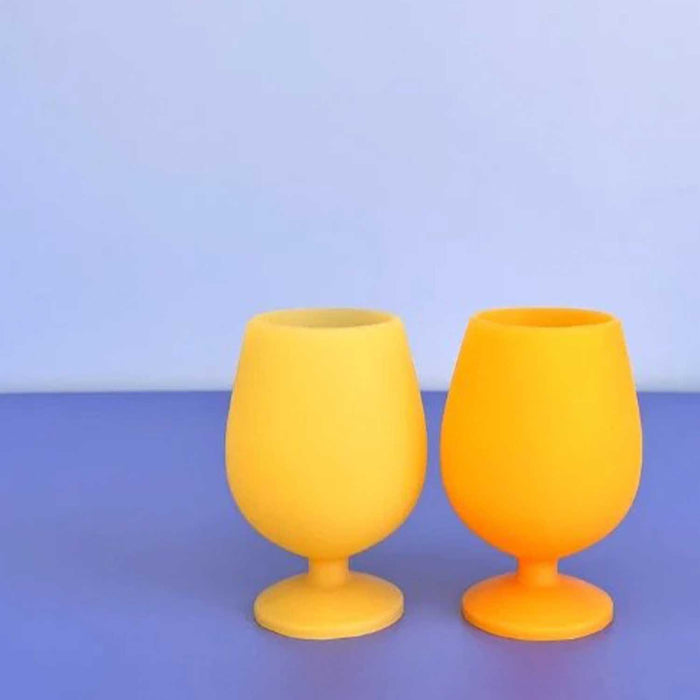 two yellow opaque wine glasses on a blue and light blue background