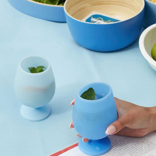 two blue wine glasses with mint leaves on a blue table with blue bowls