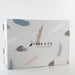 a gift box on off white background. grey with feathers on it and stork and co written in black