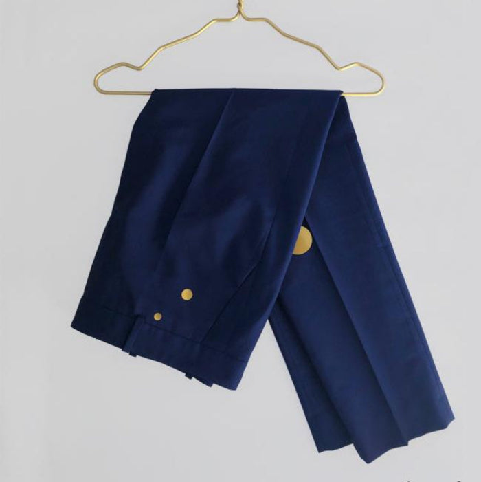 blue trousers on a gold hanger with circular gold patches