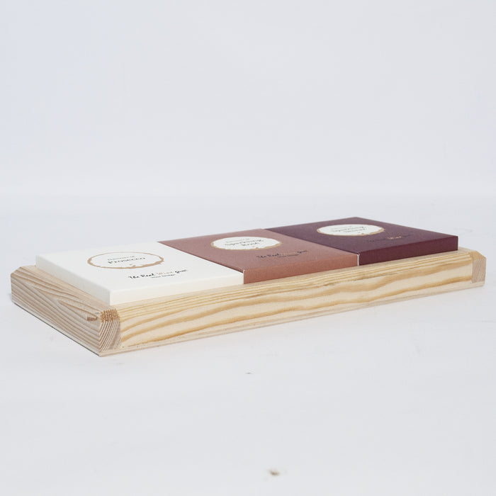A wooden frame with three different coloured boxes inside against a white surface.
