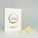 A white rectangular product box with a circular white and gold label reading 'flavours of champagne' photographed on a light surface next to yellow gummies.