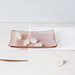 White coloured gummies on an orange glass dish against a cream and white surface.