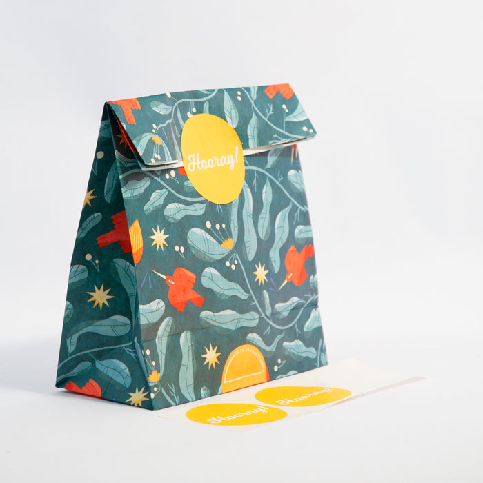 a turqoise, yellow and red reusuable gift bag with yellow stickers with the word 'hooray!' on them